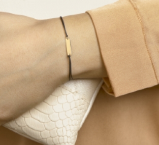 Gevlochten damesarmband met gouden plaat om pols