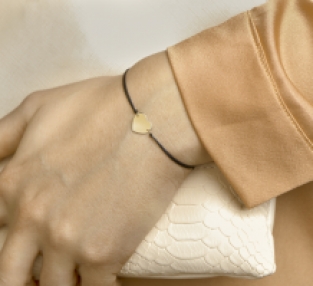 Gevlochten damesarmband met gouden hart zwart om de pols